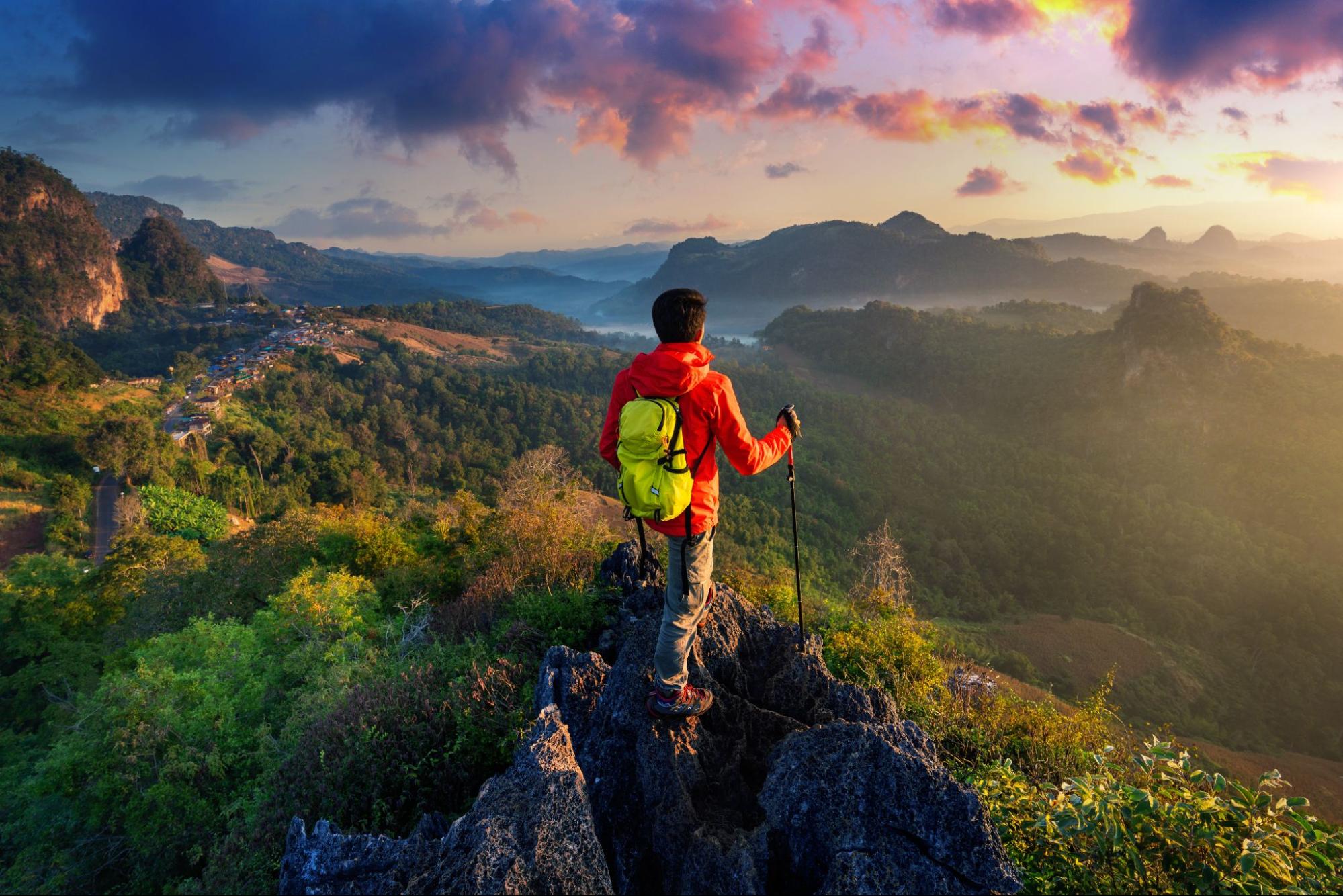 一個男人穿著登山裝望向太陽