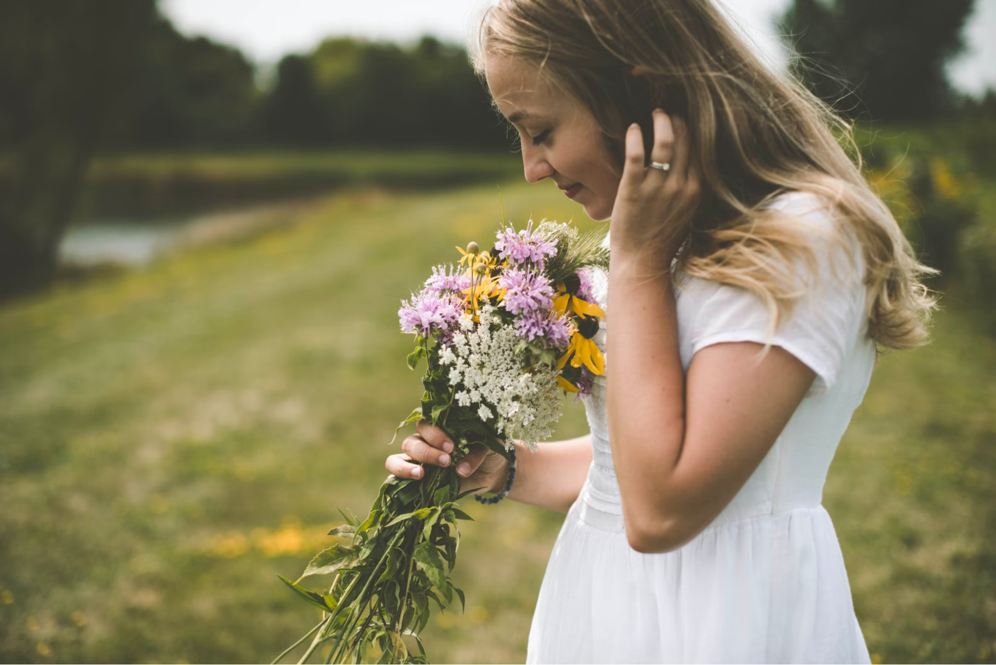 girl in the garden smelling flower
