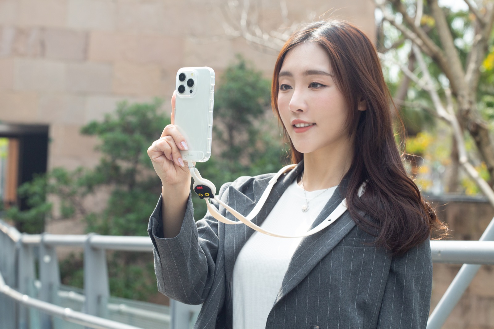 女子背著斜背頸掛手機夾片